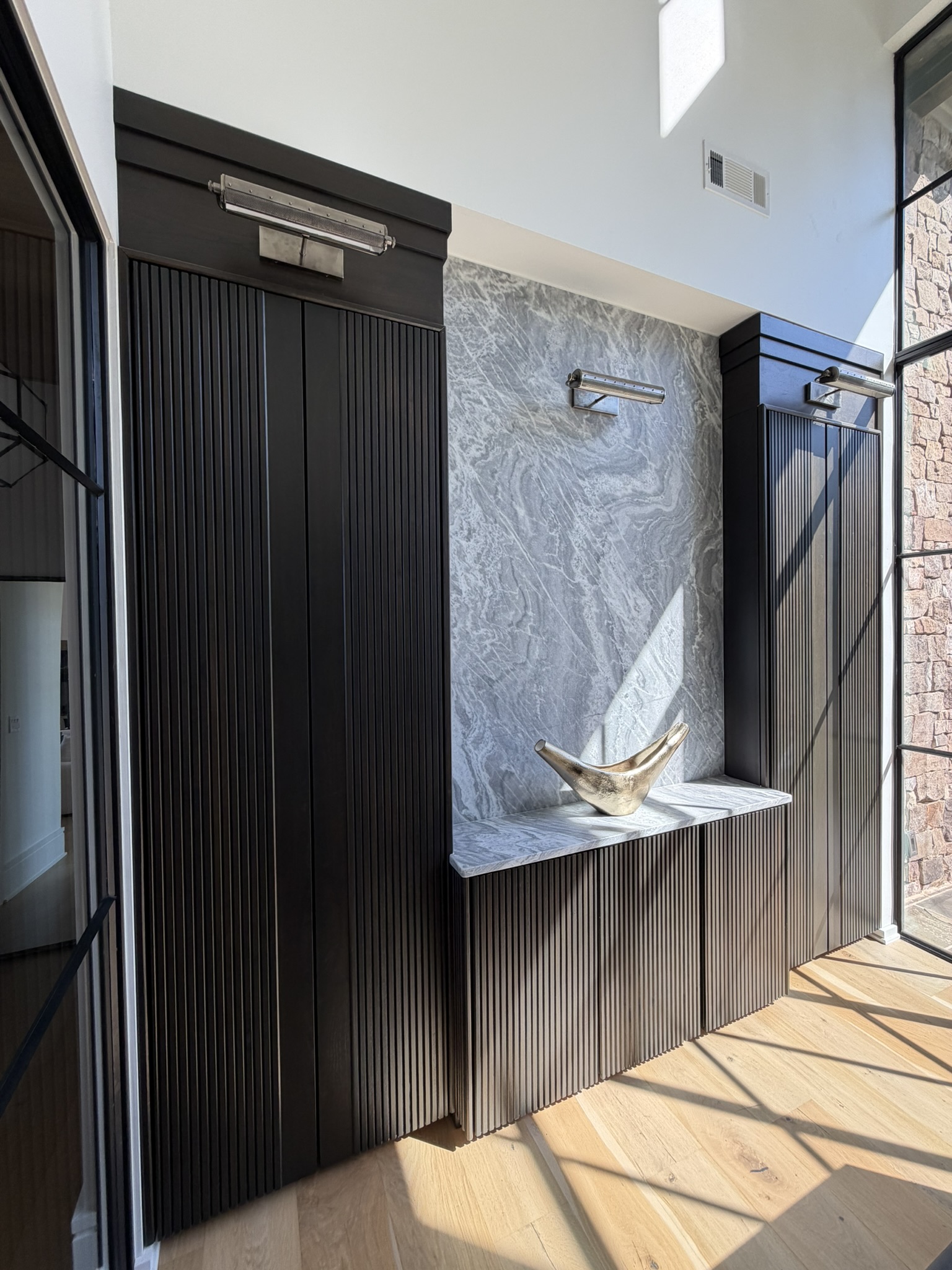 Dark fluted entry built-ins with marble