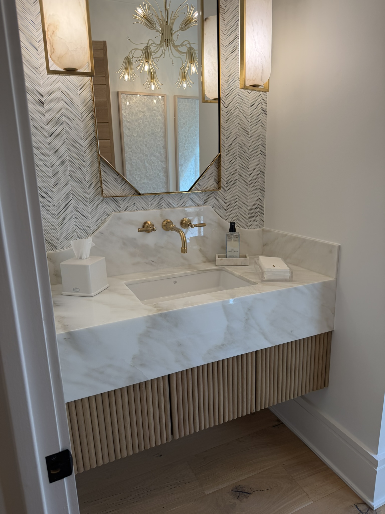 Floating powder room vanity with marble top and fluted oak base