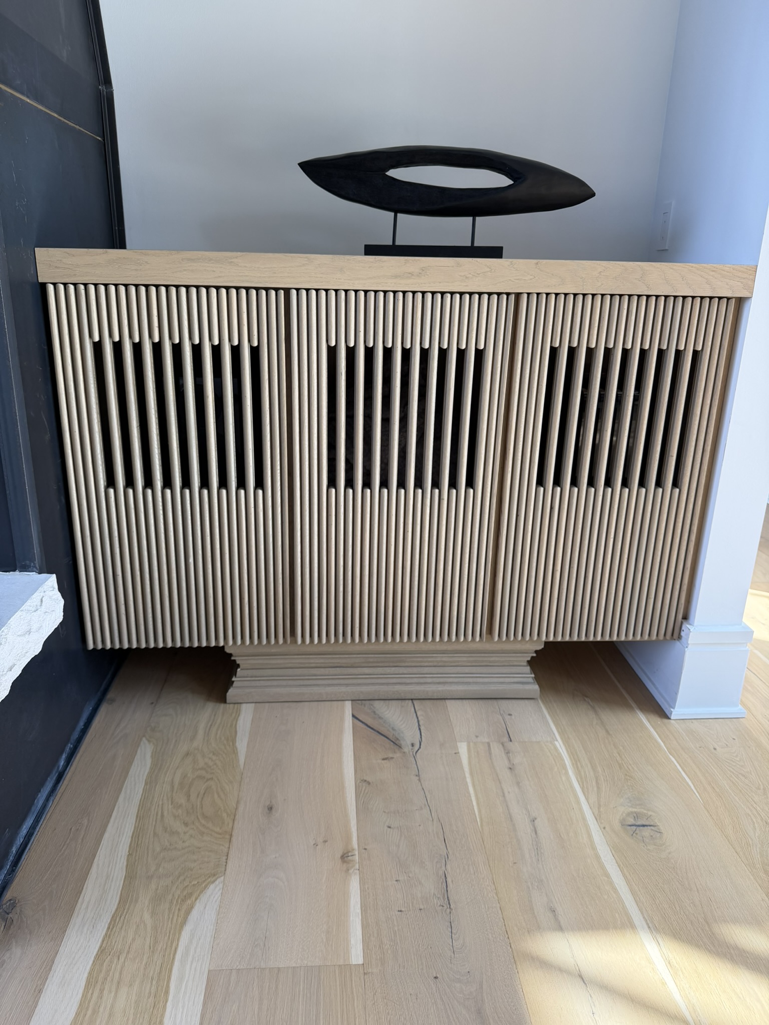 Custom oak slatted radiator cover with sculpted dowel detail