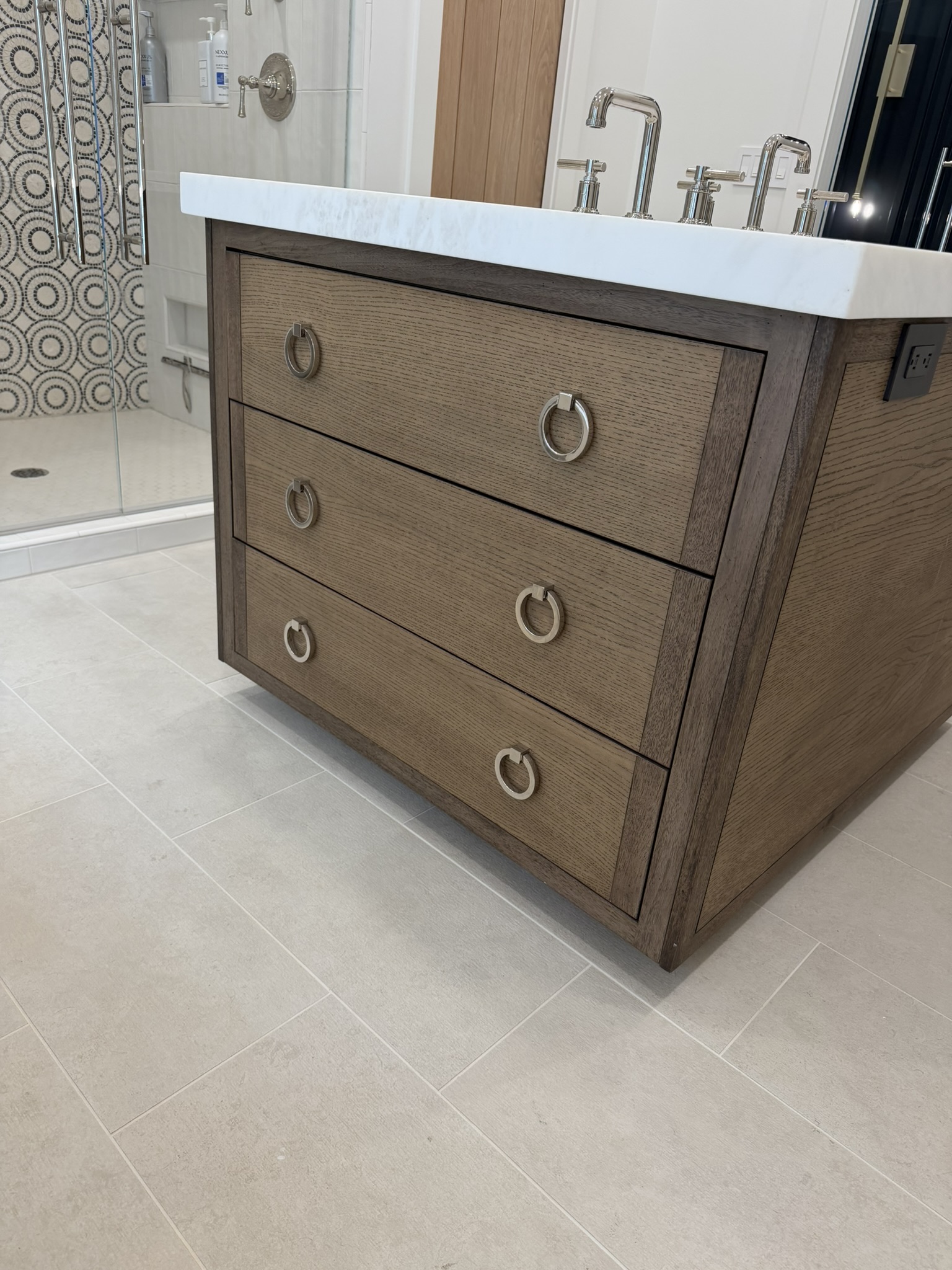 Dark oak drawer vanity with ring pulls and marble top